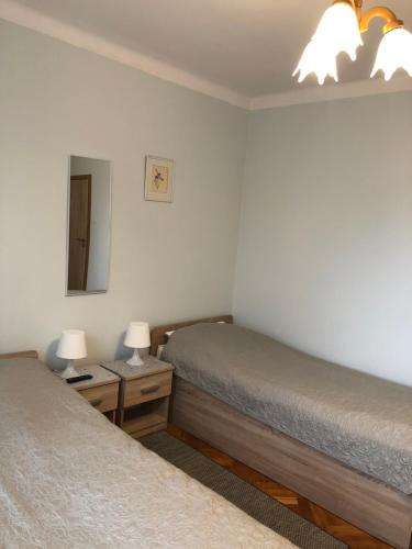 a bedroom with two beds and a mirror and two lamps at Chrobrego 269 in Biała Podlaska