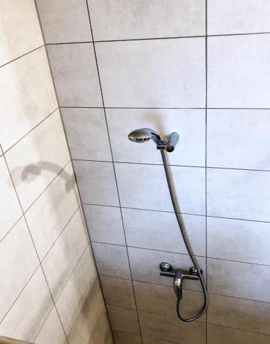 a shower with a shower head on a tiled wall at Chrobrego 269 in Biała Podlaska