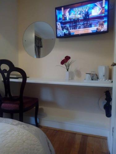 a bedroom with a mirror and a tv on a wall at Corrib View Guesthouse h91rr72 in Galway