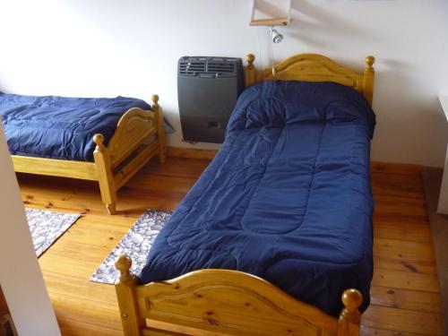 1 dormitorio con 2 camas individuales y ventilador en Cabaña Lecalau, en Lago Puelo