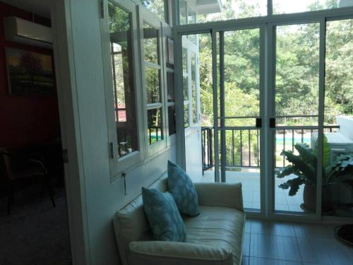 a living room with a couch with pillows at The Journey House Lifestyle Boutique Hotel in Kanchanaburi