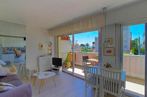 un soggiorno con divano e tavolo e un balcone di Le lutin a Saint-Laurent-du-Var