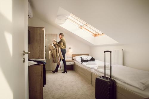 a woman standing in a hotel room with her luggage at Kings Residence in Prague
