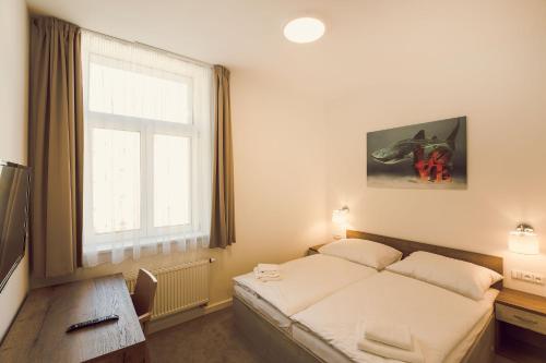 a bedroom with a bed and a desk and a window at Kings Residence in Prague