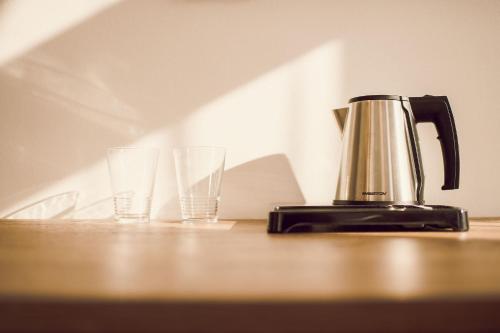a coffee pot and two glasses on a table at Kings Residence in Prague