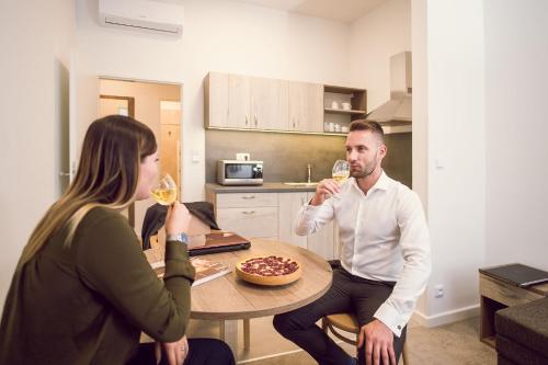 a man and woman sitting at a table drinking wine at Kings Residence in Prague