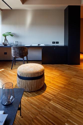 a room with a chair and a stool and a table at Delparco Hotel in Buttrio