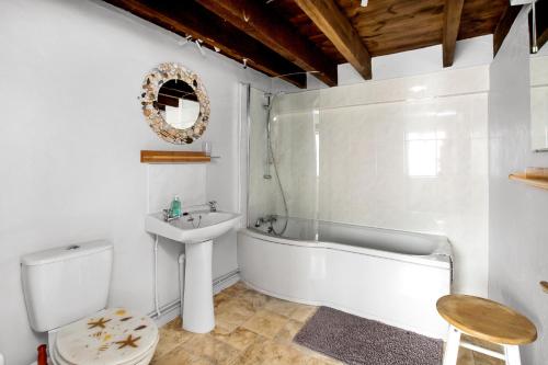 a bathroom with a tub and a sink and a toilet at Sunflowers Barn in Looe