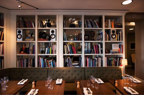 a restaurant with two wooden tables in front of a book shelf at Lydmar Hotel in Stockholm