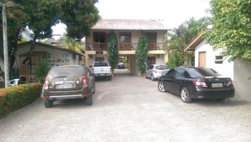 a group of cars parked in front of a house at Pousada Tropicalia in Itaparica Town