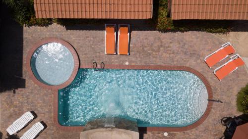 an overhead view of a swimming pool with two chairs at Costa Esmeralda Village in Palm-Eagle Beach