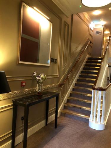a staircase with a vase of flowers on a table at Hotel 7 in Dublin