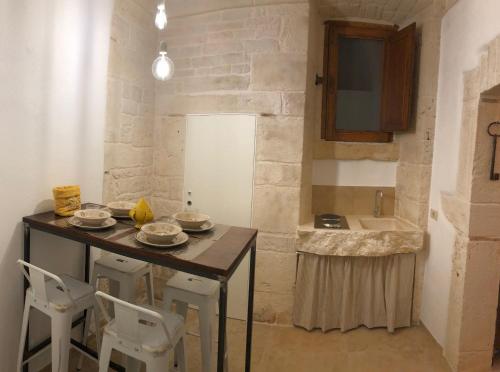 a kitchen with a table and chairs and a sink at Dimora Miccolis in Alberobello