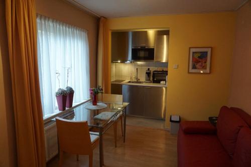 een woonkamer met een tafel en een keuken bij B&B Bosrand in Groesbeek