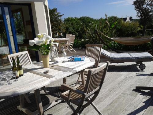 une table en bois avec des chaises et un hamac sur la terrasse. dans l'établissement Villa 