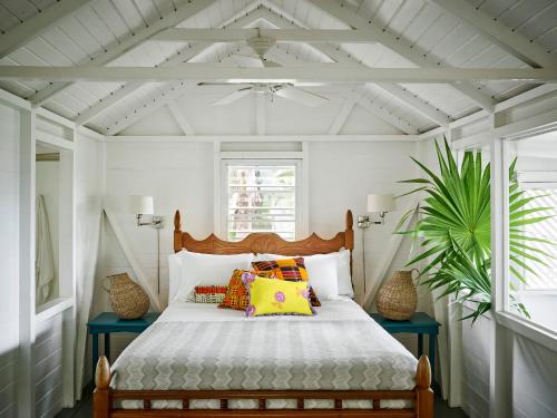 a bedroom with a bed with colorful pillows on it at Golden Rock Nevis in Nevis