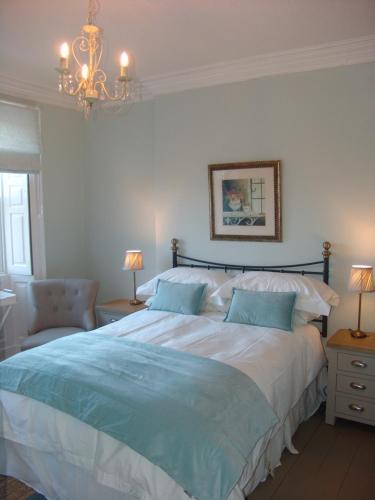 a bedroom with a large bed and a chandelier at Osborne House B&B Workington in Workington
