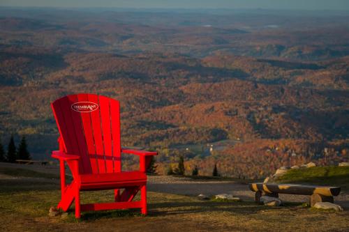 a red chair sitting on top of a hill at Chalet Le Convivial Tremblant in Lac-Superieur
