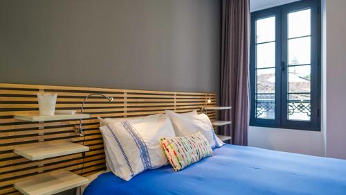 a bedroom with a blue bed with two pillows at Cílio House - Duplex in Ponta Delgada