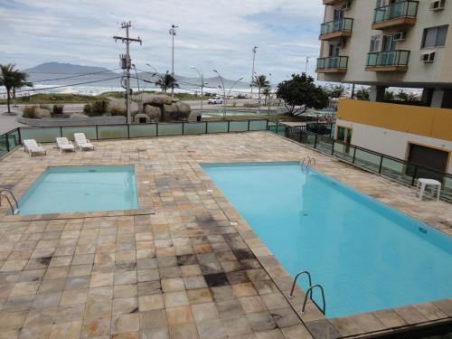 uma piscina ao lado de um edifício em Praia do Forte - Condomínio Forte da Praia em Cabo Frio