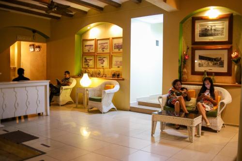 a group of people sitting in chairs in a lobby at Hotel Petén Express in Flores