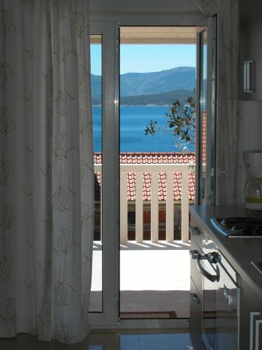 a kitchen with a sliding glass door to a balcony at Apartments & Rooms Luna in Bol