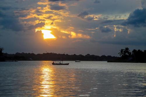 a boat on the water with the sun setting at Hotel Petén Express in Flores