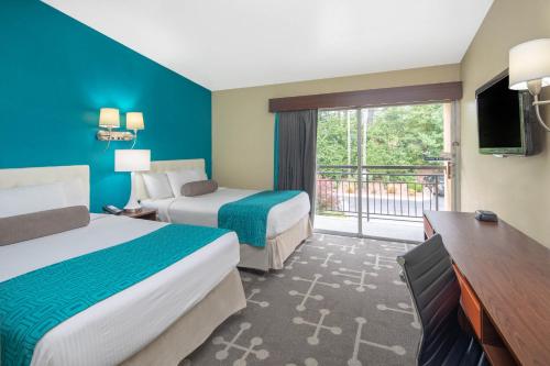 a hotel room with two beds and a balcony at Howard Johnson by Wyndham Athens in Athens