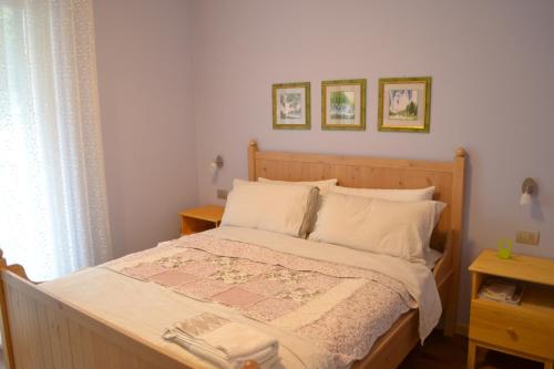 ein Schlafzimmer mit einem Bett und zwei Bildern an der Wand in der Unterkunft La Bella Italia in Desenzano del Garda