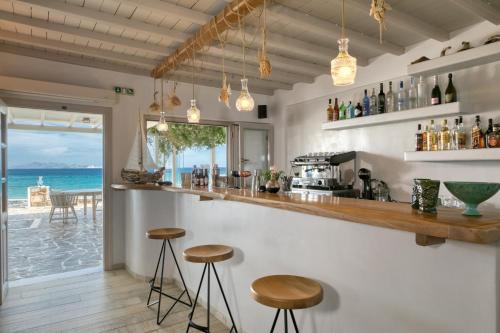 a bar with stools and a view of the ocean at Ostria Inn in Moutsoúna