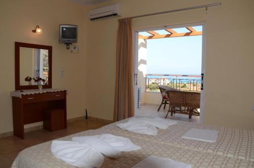 sypialnia z łóżkiem, biurkiem i oknem w obiekcie Elafonisos Diamond Resort w Elafónisos