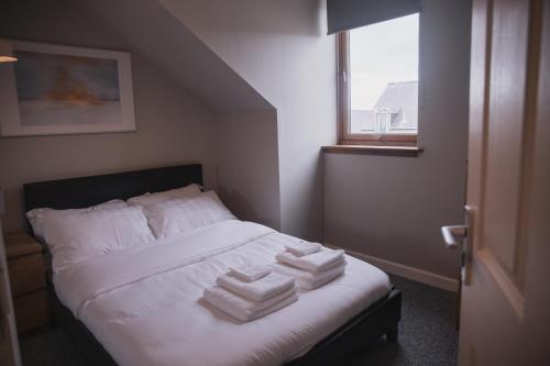 a bedroom with a bed with towels on it at Townhouse on the Spital in Aberdeen