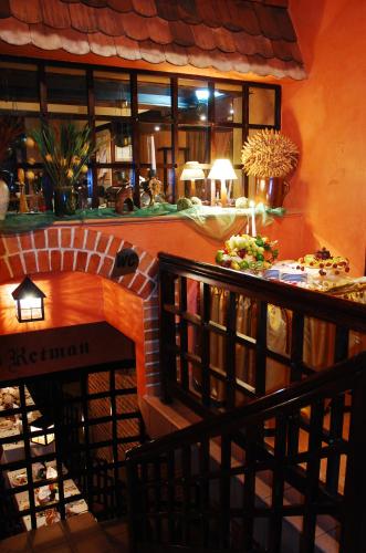 a room with a library with a table with books at Hotel Retman in Toruń