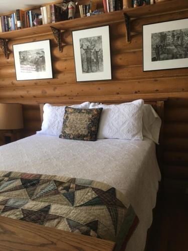 una camera da letto con un letto con immagini appese al muro di Canyon Wren Bed and Breakfast a Bluff