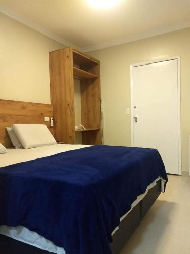 a bedroom with a blue blanket on a bed at Hotel Saint Lucas in São Paulo
