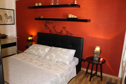 クアルトゥ・サンテーレナにあるSandan Homeの赤い壁のベッドルーム1室(ベッド1台付)