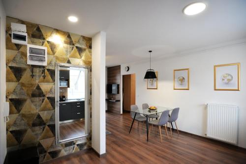 a dining room and kitchen with a table and chairs at ONE Luxury Suites Eger in Eger