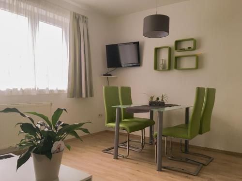 a dining room with a table and green chairs at Haus-Iris-Mauerbach in Mauerbach