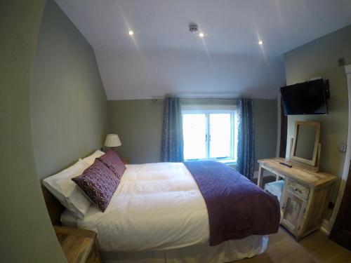 a bedroom with a bed and a window and a television at The Courtyard in Bewdley