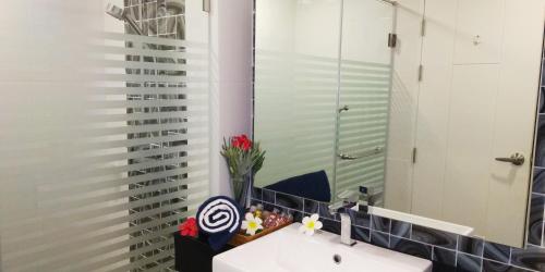 uma casa de banho com um lavatório e um espelho em Dusit Grand Park Condo em South Pattaya
