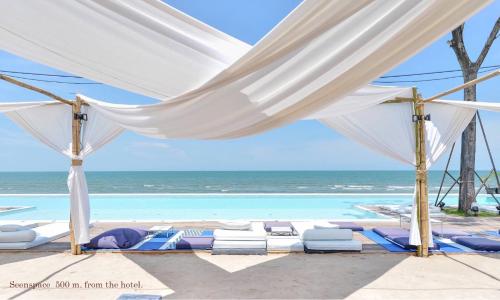 a marquee at a beach with chairs and the ocean at A Villa Hua Hin Hotel in Hua Hin