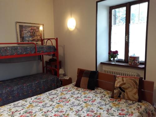 een slaapkamer met een bed en een stapelbed bij Alla casa del cedro in Cavedago