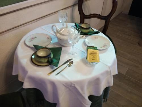 a table with a white table cloth and a tea set at B&B Casa dell'Orso in Lurisia