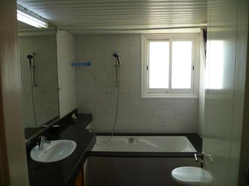 a bathroom with a sink and a tub and a toilet at Private deluxe room with balcony at Datacom building in Nicosia