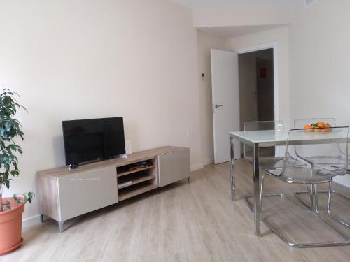 een woonkamer met een tafel en een televisie op een kast bij RUZAFA CENTRO AIRE ACONDICIONADO WiFi in Valencia