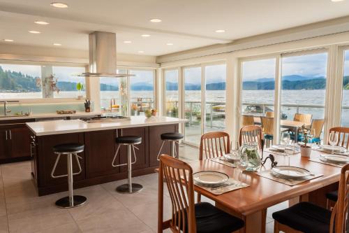 a kitchen and dining room with a view of the water at Walls of Glass Hood Canal Vacation Rental in Union