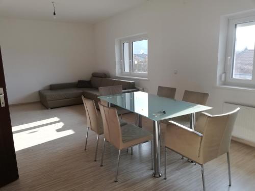 a dining room with a glass table and chairs at Modernes 2-Zimmer-Apartment nahe Graz in Gratkorn