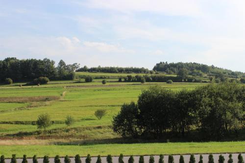 a field of green grass with a wooden fence at Dwór Bysina in Myślenice
