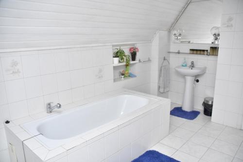 a white bathroom with a tub and a sink at Penzion Na Kopečku in České Budějovice