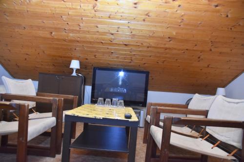 a living room with a table and chairs and a television at Penzion Na Kopečku in České Budějovice